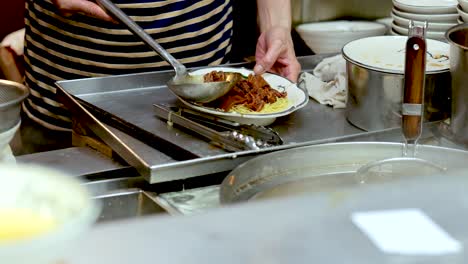 chef assembles noodle soup with pork in hong kong