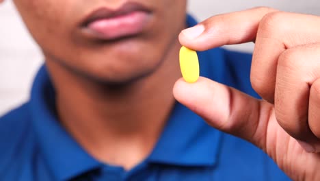 person holding a yellow pill