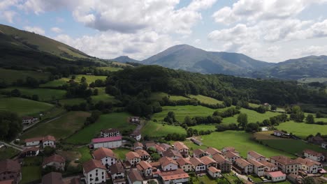 Tilt-up-aerial-shot-revealing-the-cozy-village-of-Amaiur-Maya,-municipality-of-Baztan-Valley