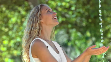 mujer feliz en cámara lenta atrapando agua
