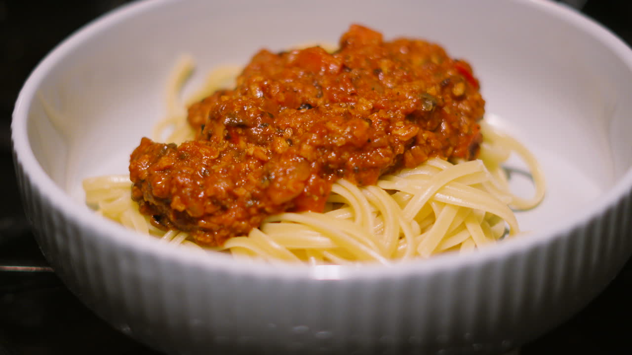 Panning Up Shot of Spaghetti Bolognese Pasta Dish. Italian Food Traditional Classic Cuisine Made with Beef Mince and Vegetables including Mushrooms, Peppers, Onions 4K.