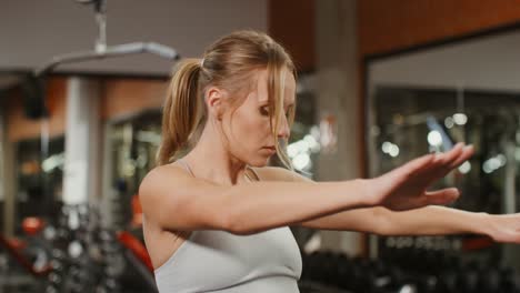 mujer estirándose en el gimnasio