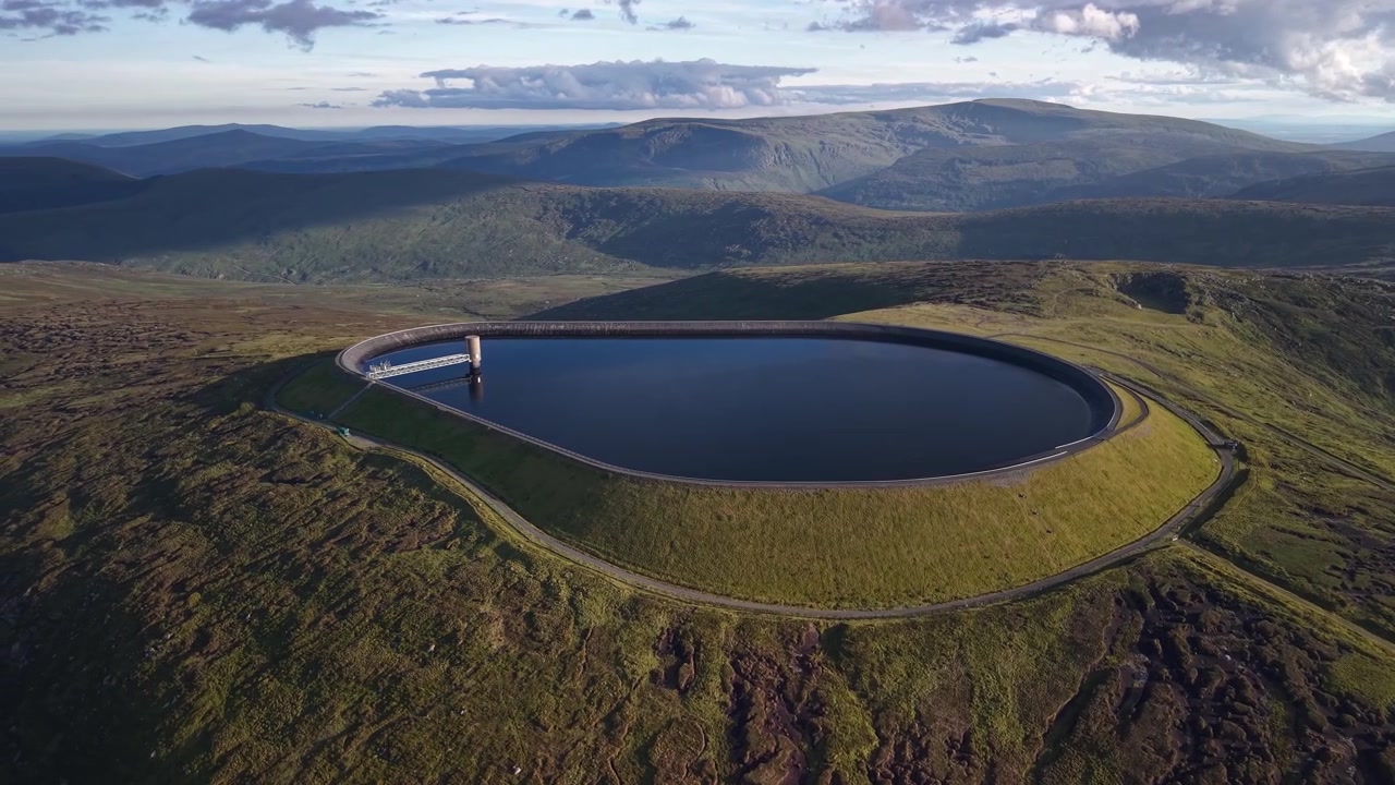 Panorama drone indah Waduk Turlough Hill dalam cahaya matahari terbenam keemasan, County Wicklow