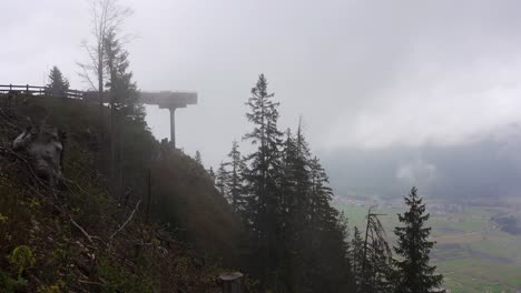 Una-Plataforma-De-Observación-Parcialmente-Oscurecida-Por-Nubes-Bajas-En-Un-Valle-En-Las-Montañas-De-Los-Alpes