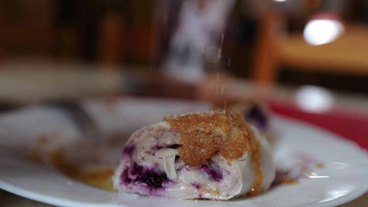 close up del plato tradicional esloveno struklji en un plato cubierto de azúcar