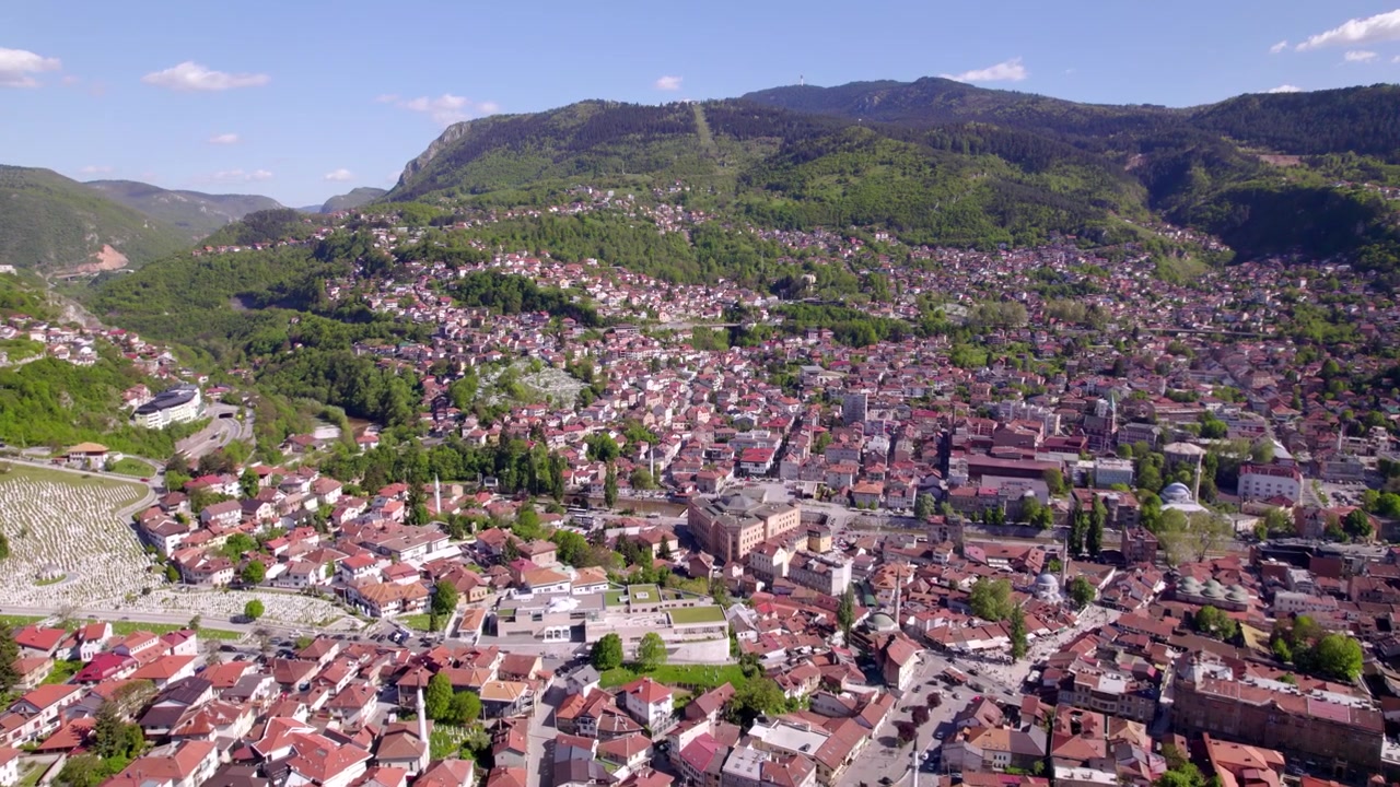Panorama aereo della città di Sarajevo con fitte abitazioni che si arrampicano sui pendii montuosi boscosi, ripreso con drone, Bosnia ed Erzegovina