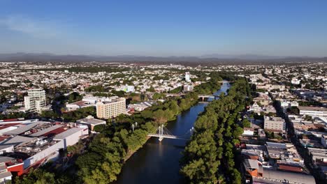 aerial overview of the río tamazula river, in sunny culiacan, mexico - circling, drone shot