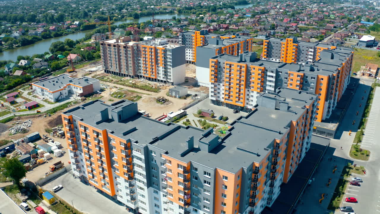 High-rise apartment buildings in the countryside. New complex of modern apartment buildings near the river. Multi-storey housing. Aerial view. Rising up.