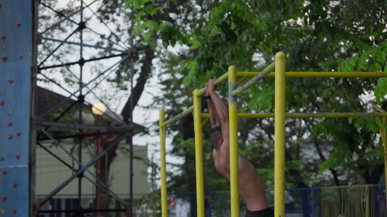 Man exercising on parallel bars in an outdoor gym