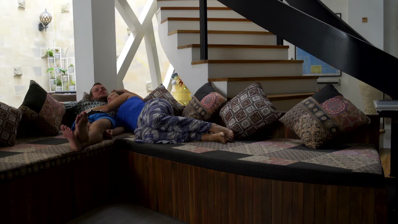 한 남자 와 한 여자 가 집 의 소파 에 누워 있다