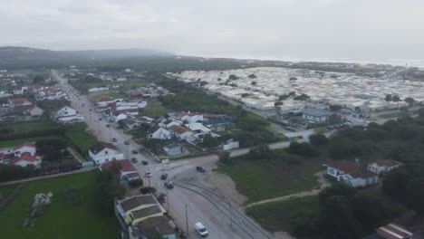 a short drone shot, diagonaly flying above a coastal village in costa da caparica, portugal.