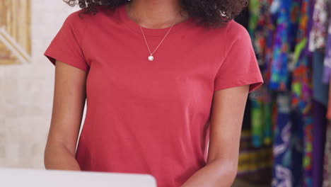 portrait of female owner of independent clothing and gift store behind sales desk