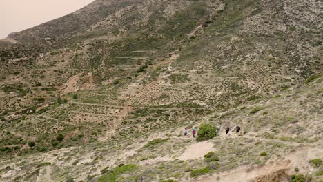 los turistas están caminando, haciendo trekking a lo largo de un sendero de montaña en las altas montañas de grecia