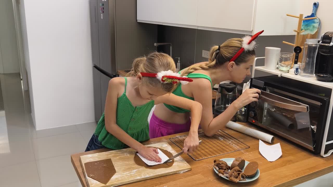 дети и мама делают рождественские печенье с имбирным хлебом.