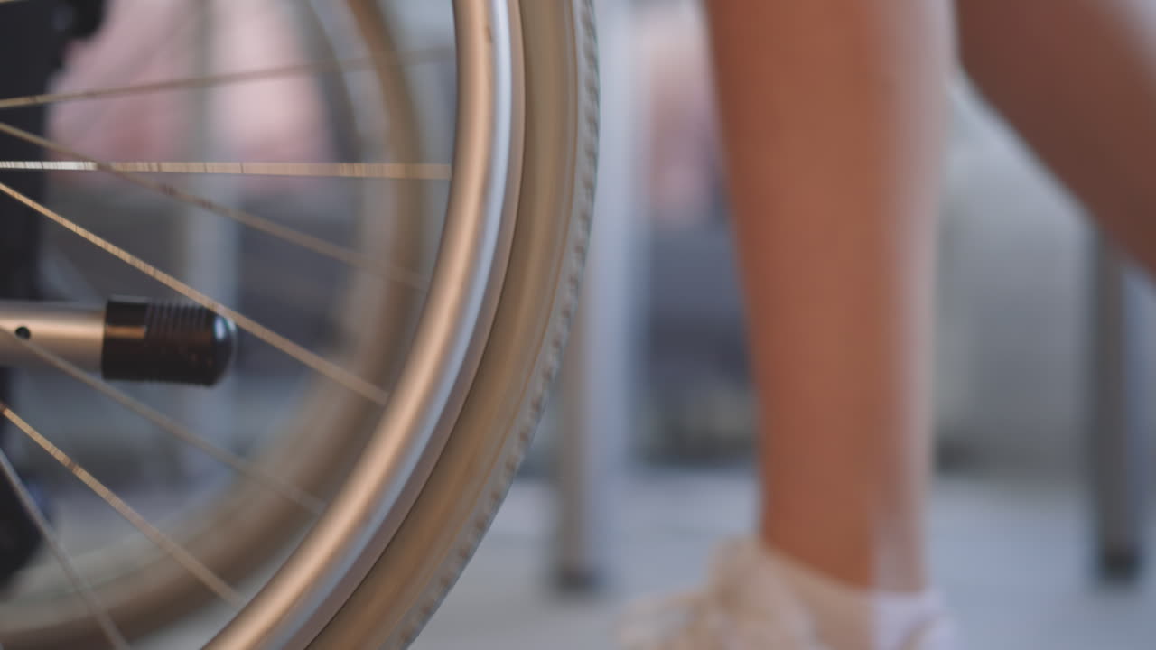 piernas de una enfermera joven empujando una silla de ruedas con ruedas grandes