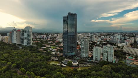 anacaona 27 tower skyscraper and enriquillo lake, mirador sur, santo domingo cityscape in dominican republic. aerial orbiting