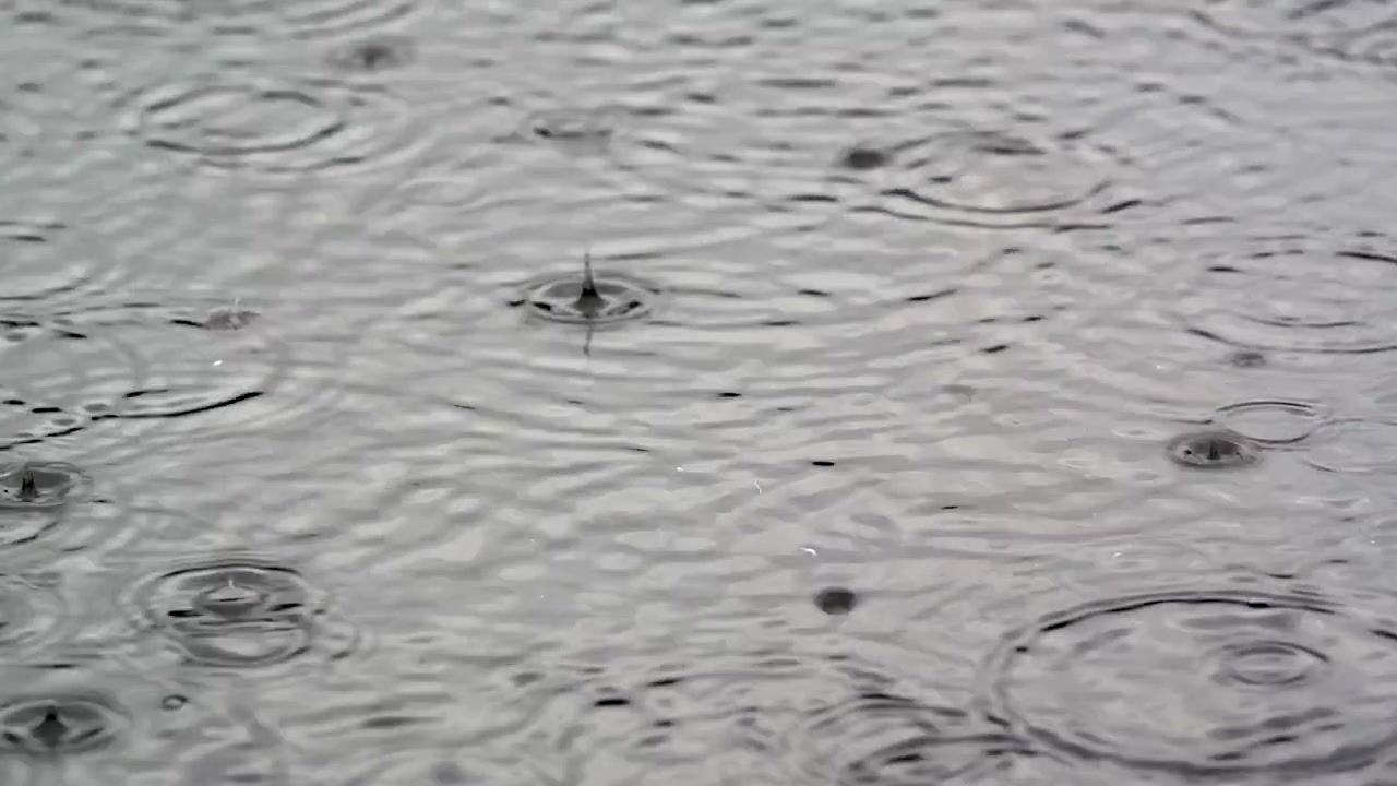 Gotas de Chuva Caindo em uma Superfície de Água Calma Criando Ondulações