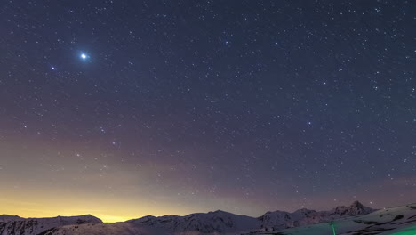 stars crossing the sky above a winter mountain landscape - wide angle time lapse