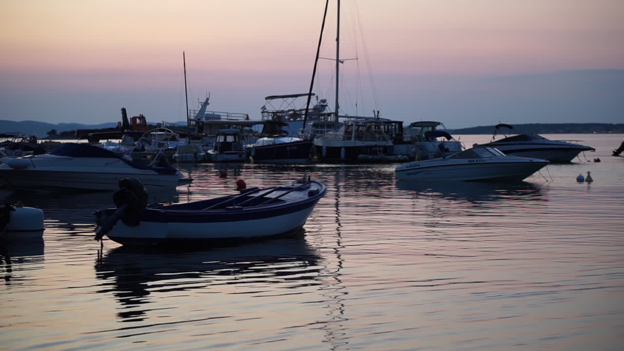 Yacht, motoscafi e pescherecci che galleggiano in mezzo al mare all'alba - Piano medio