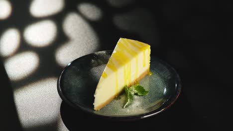 a piece of lemon sweet dessert on a plate on a black background.