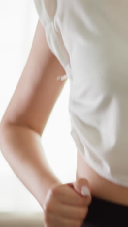 mujer corre en entrenador en casa de cerca. mujer delgada con camiseta blanca corre en entrenamiento cardio en gimnasio doméstico. deportista entrenada disfruta de hacer ejercicio regularmente