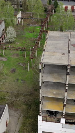 ruined industrial building. old unfinished architecture of a factory. abandoned territory of manufacturing. aerial view. vertical video