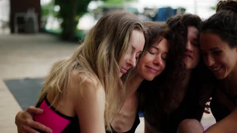 happy yoga group hugging and smiling after workout on the terrace, close up