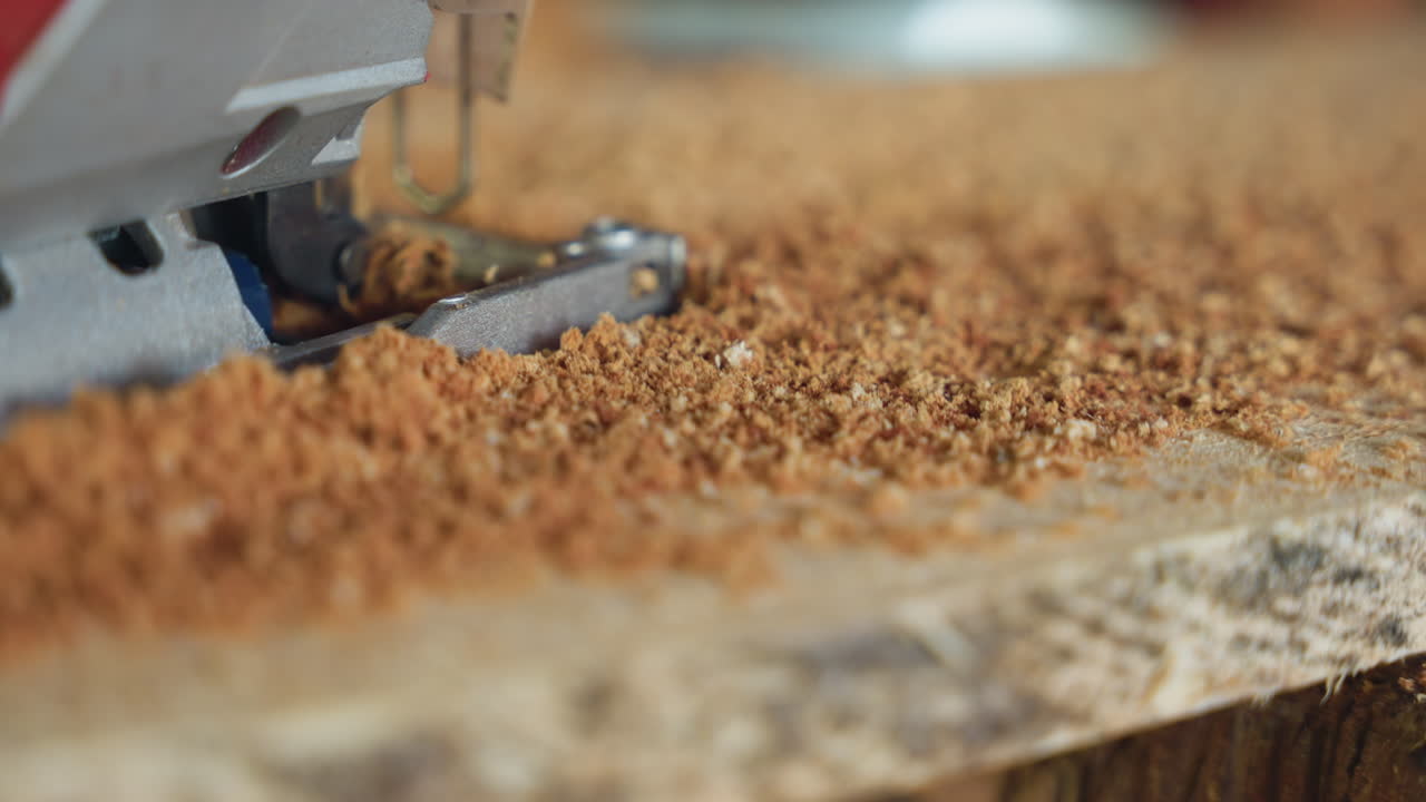 Dynamic jigsaw cutting particleboard sawdust flying, rough renovation site vibe, fast power cut, aggressive edge trimming, coarse shavings scattering, red saw housing and blade shoe visible