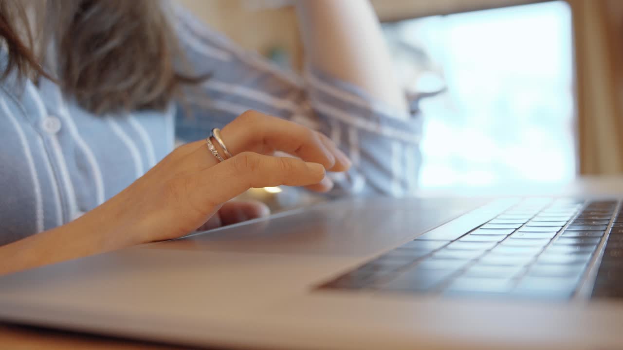 Woman working on laptop at home, symbolizing focus and productivity, neutral tones