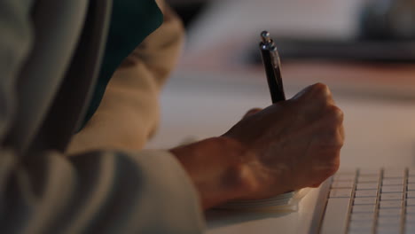 close up business woman hands writing notes brainstorming creative ideas for projectworking late in office at night