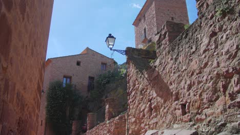 red brick walls of houses from old medieval streets in vilafames, castellon, spain - medium panning shot