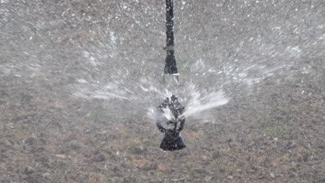 Nahaufnahme-Des-Wassers,-Das-Von-Einem-Oszillierenden-Kopf-Gesprüht-Wird,-Der-Am-Zentralen-Drehpunkt-Bewässerungssystem-Befestigt-Ist