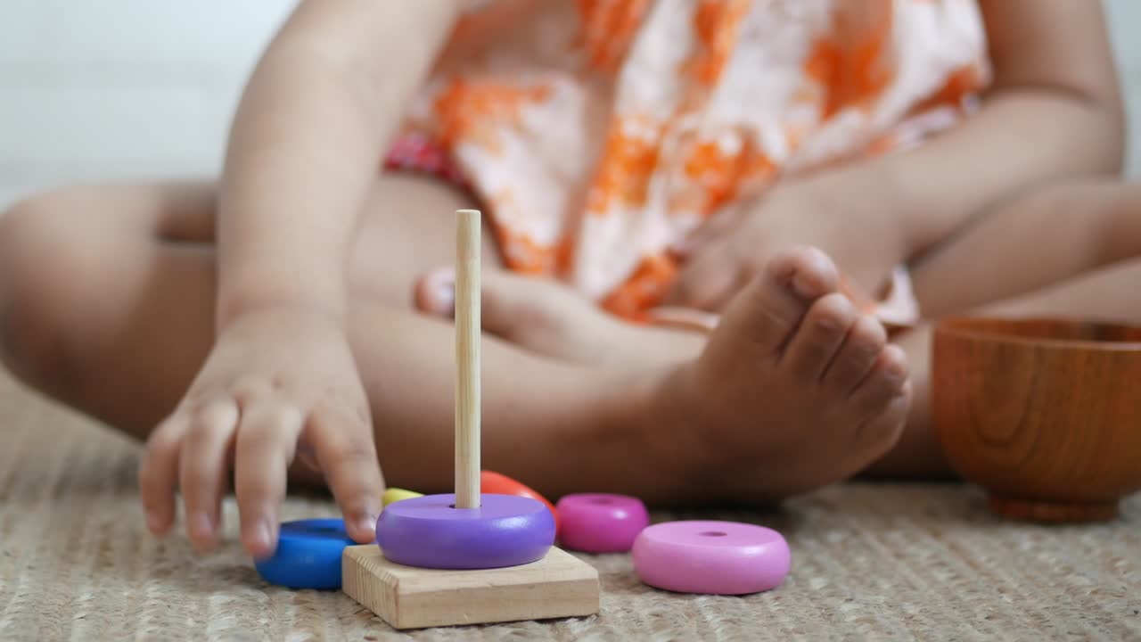 niño jugando con juguetes de bebé en la cama, concepto de desarrollo infantil.