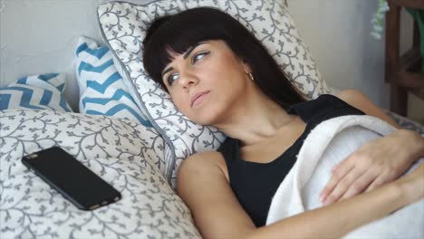 woman sleeping in bed with phone