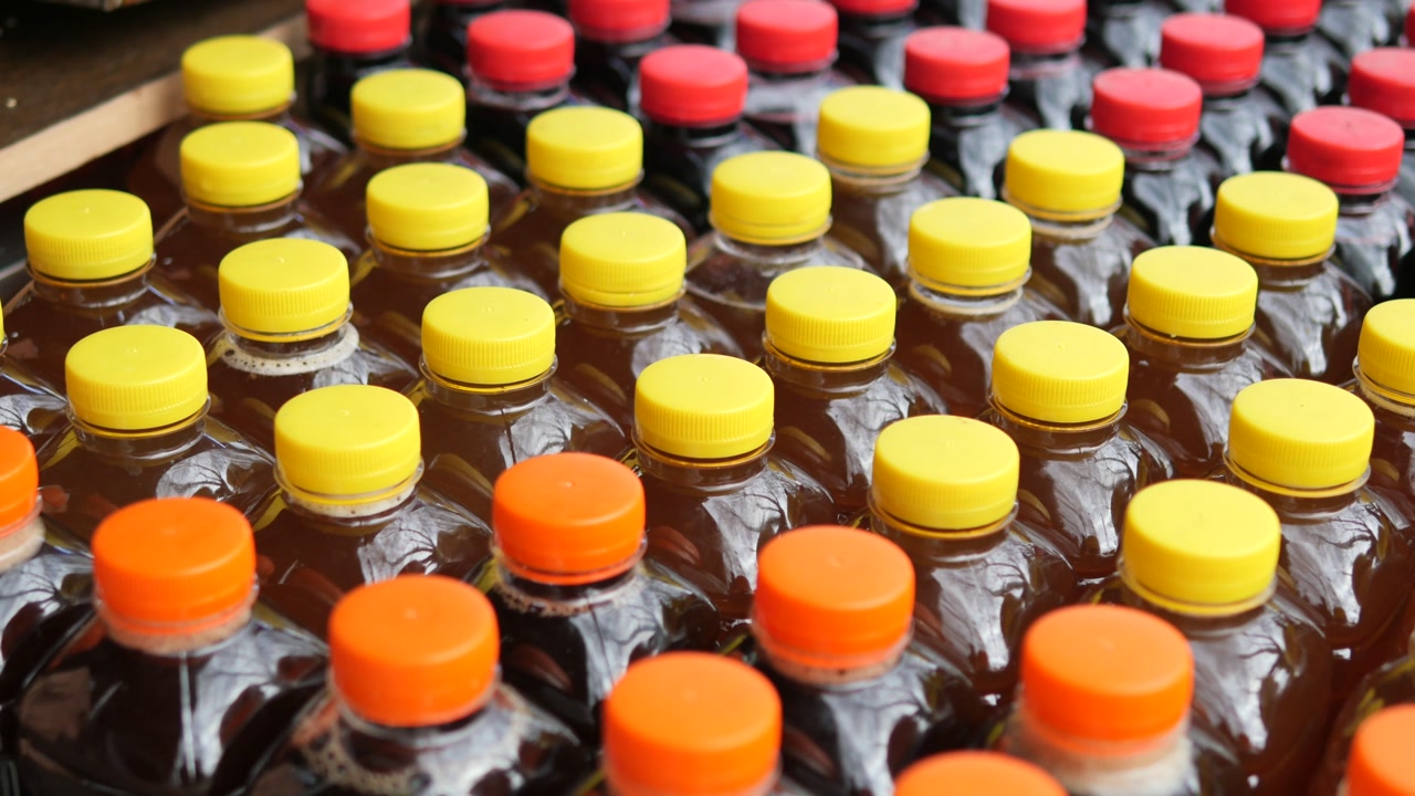 Rækker af plastdrikkeflasker med farverige låg