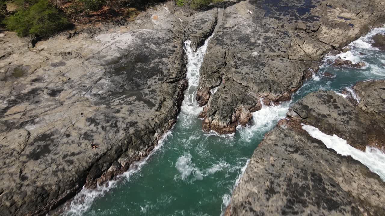 costa rica, costa de piedra rocosa con olas salpicando contra las piedras, disparo de drone dji