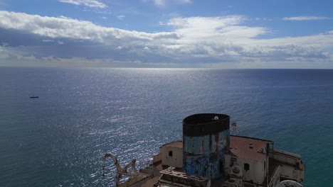 Dramatic-aerial-view-flight-Rusty-haunted-ghost-ship-Shipwreck-on-beach-Lanzarote-Canary-Islands,-sunny-day-Spain-2023