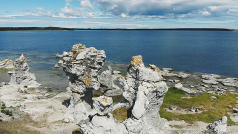 aerial birds eye drone view of calm baltic sea and interesting rock formation in coastline of gotland island with beautiful clouds