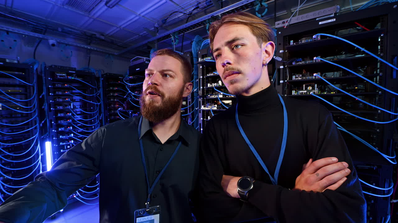 Two men analysing data in a server room