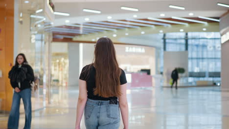 shopper holding shopping bags in mall, turning and looking around curiously, flaunting her hair while walking through vibrant shopping center, with other shoppers passing by