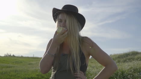 Slomo-De-Mujer-Joven-Comiendo-Una-Manzana-En-Un-Campo-De-Flores