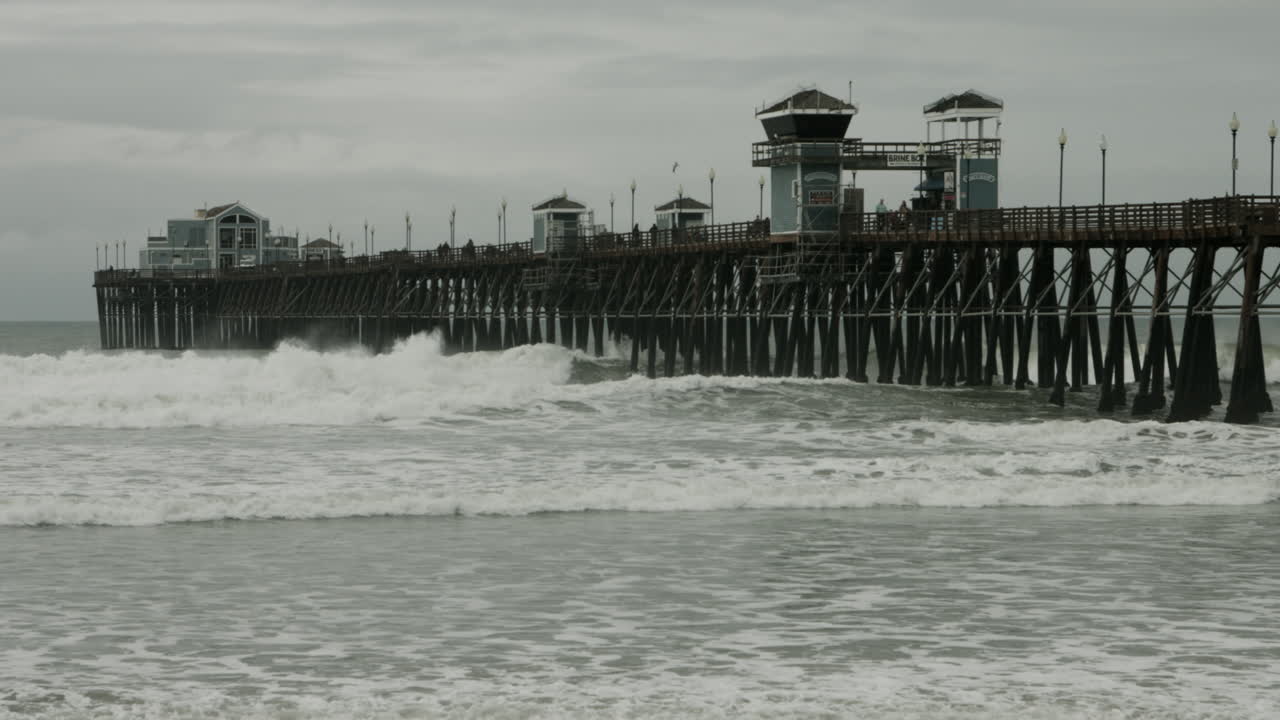 Waves crash into the pier in Oceanside, California