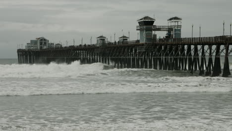 las olas chocan contra el muelle en oceanside, california.