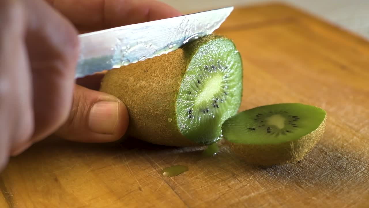 cortando deliciosas fatias de kiwi em uma placa de madeira
