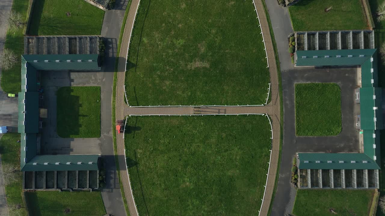 Cinematic 4K drone footage of world class equine training grounds and racing yards in Newmarket England featuring thoroughbred stallions and mares