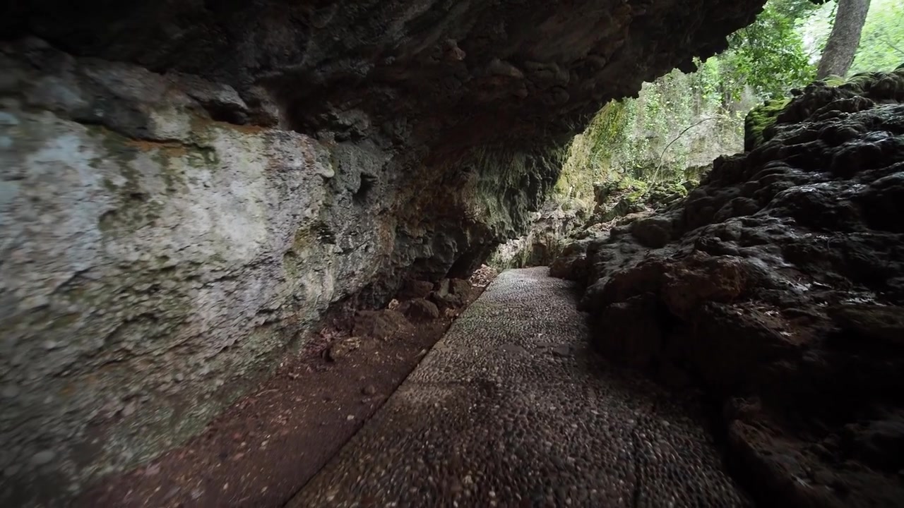 Camminando attraverso un passaggio di grotta buio con un sentiero di ciottoli