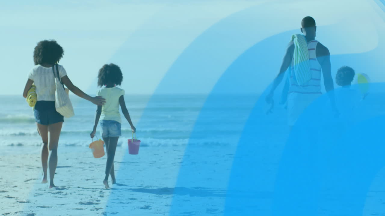 Carrying colorful buckets, family walking on beach with blue animation overlay