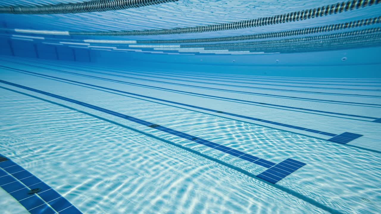 Olympisk svømmebassin under vandbaggrund.