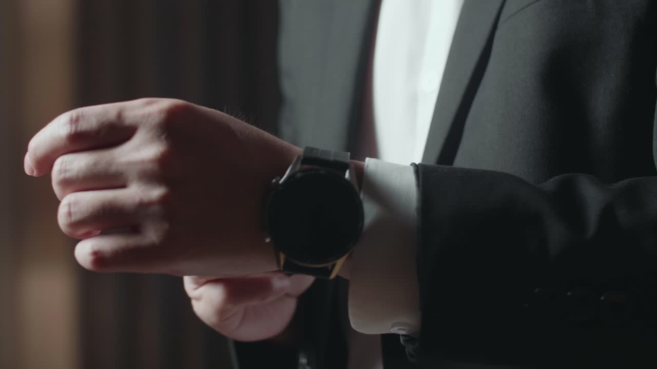 hombre de traje ajustando su reloj inteligente