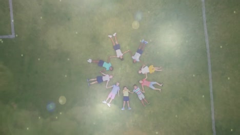 children lying on the grass holding hands